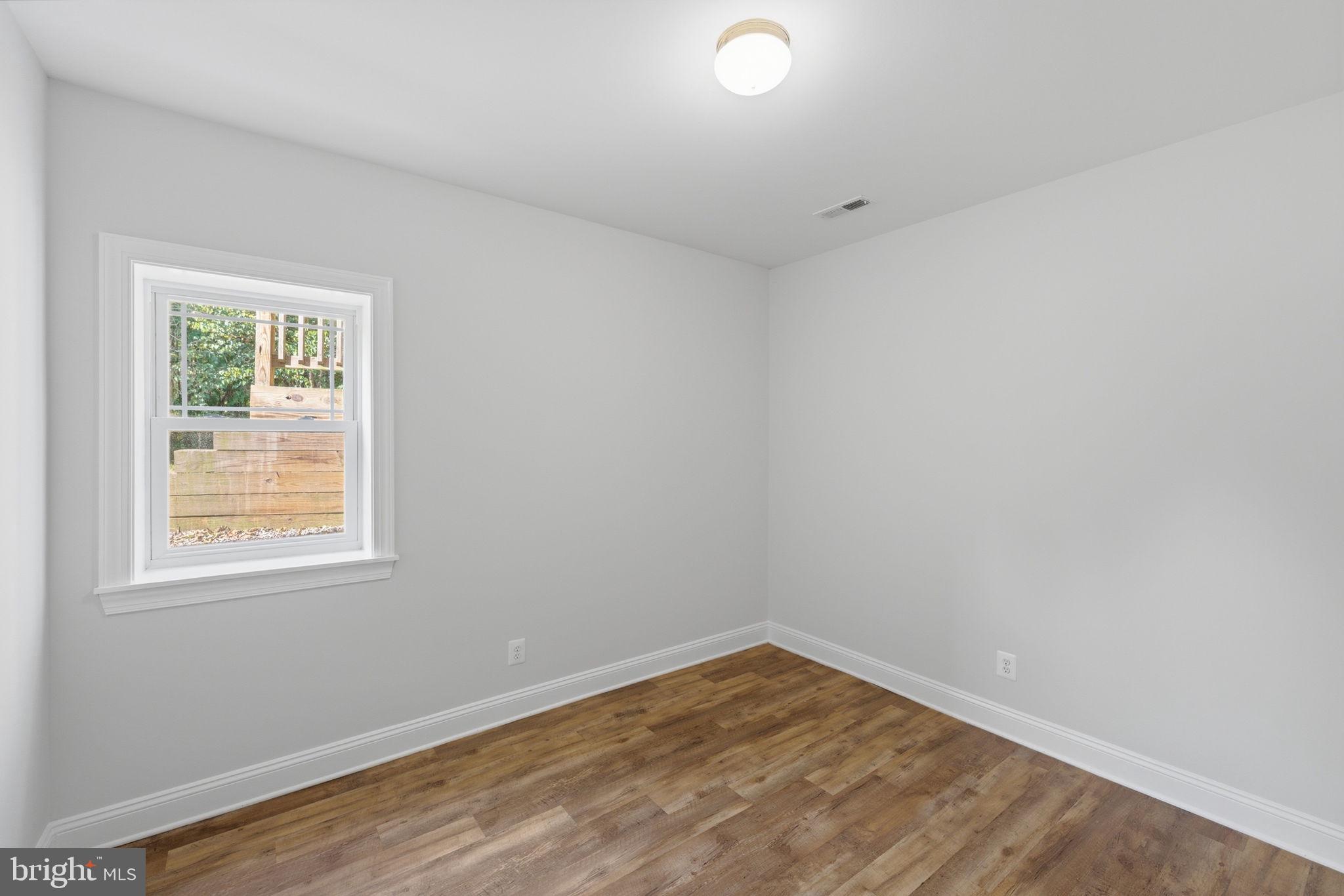 7522 Stubbs Bridge Road Spotsylvania, VA 22551 - Photo 29 of 60 an empty room with wooden floor and windows
