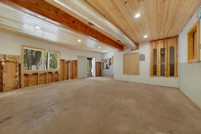 a backyard of a house with large trees and outdoor seating