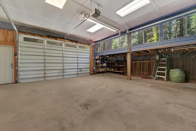 a view of a house with a yard and large trees