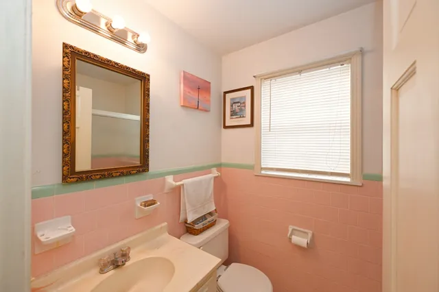 a spacious bathroom with a toilet a sink and a mirror