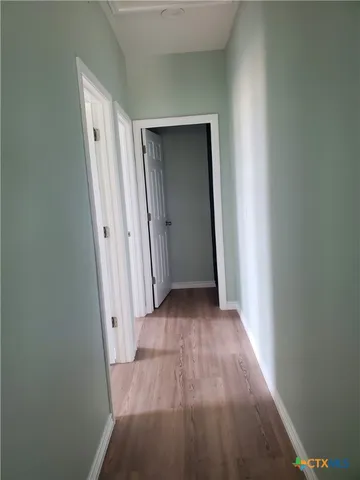 a view of a hallway with wooden floor