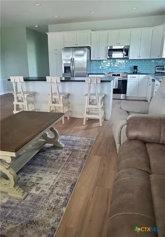 a living room with stainless steel appliances granite countertop furniture and a kitchen counter top