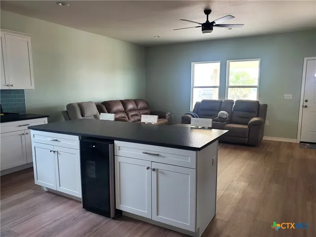 a kitchen with granite countertop a sink cabinets and wooden floor