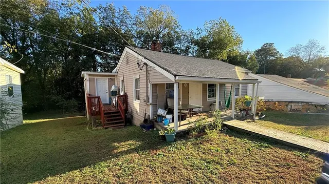 a view of a house with backyard sitting area and garden