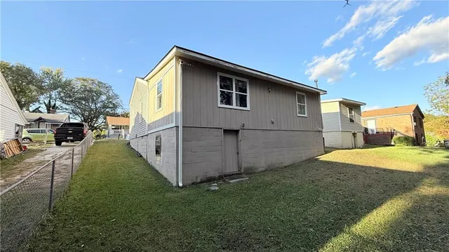 a view of backyard of house with wooden fence
