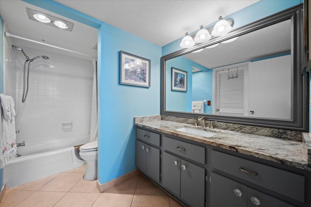 1200 Marine Way, Unit 304 North Palm Beach, FL 33408 - Photo 16 of 31 a bathroom with a granite countertop sink a toilet a mirror and shower