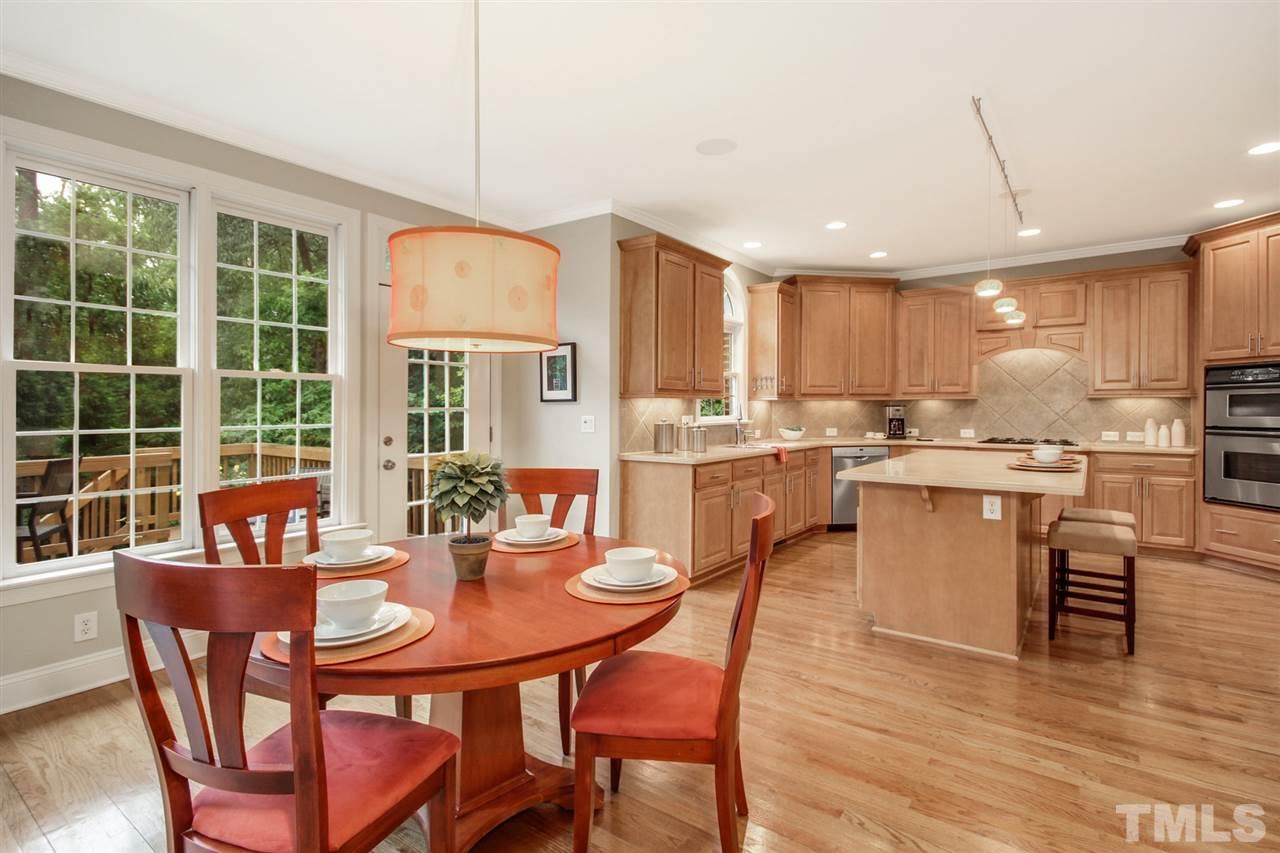 2109 CRIGAN Bluff Drive Cary, NC 27513 - Photo 11 of 30 a kitchen with stainless steel appliances granite countertop a stove a refrigerator a kitchen island a table and chairs