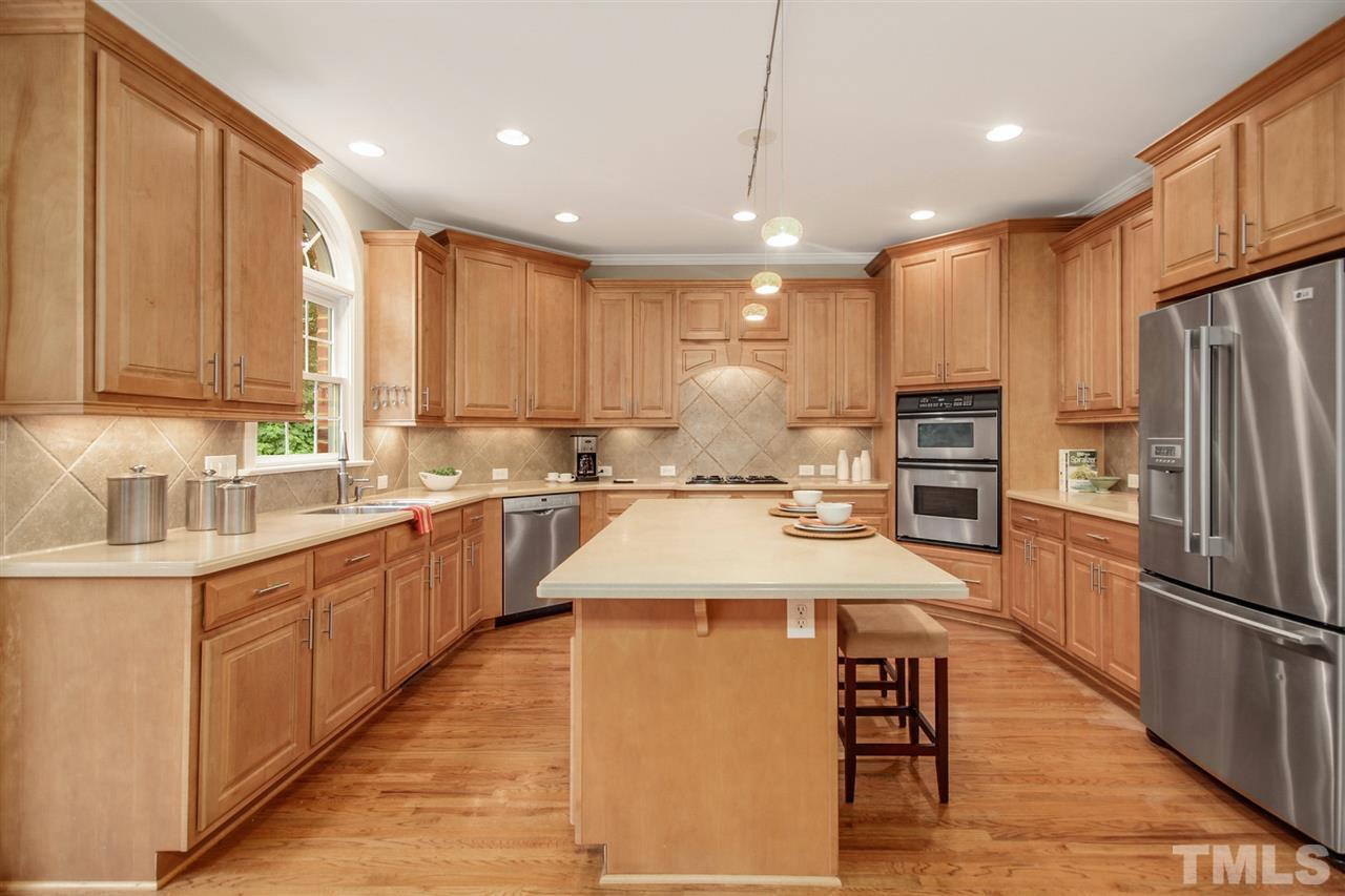 2109 CRIGAN Bluff Drive Cary, NC 27513 - Photo 12 of 30 a large kitchen with stainless steel appliances kitchen island granite countertop a sink refrigerator and cabinets