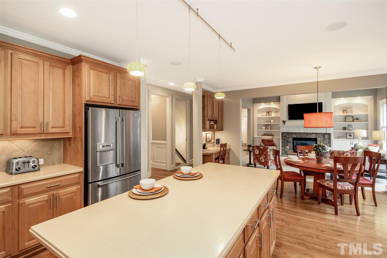 2109 CRIGAN Bluff Drive Cary, NC 27513 - Photo 13 of 30 a kitchen with stainless steel appliances kitchen island granite countertop a dining table chairs and a refrigerator