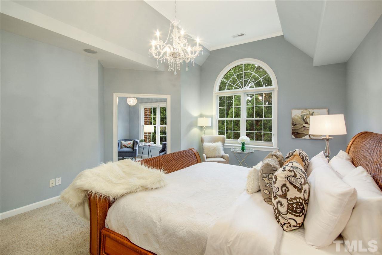 2109 CRIGAN Bluff Drive Cary, NC 27513 - Photo 15 of 30 a bedroom with a large bed and a chandelier