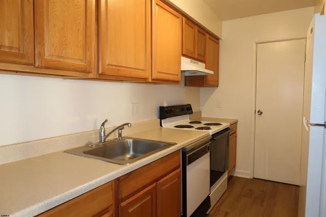 a white refrigerator freezer and a stove sitting inside of a kitchen