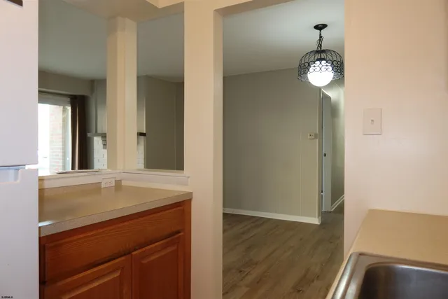 a view of an empty room with wooden floor and closet