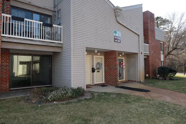 a view of an empty room with wooden floor and a fireplace