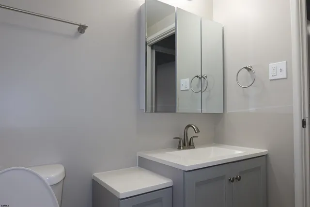 a view of an empty room with wooden floor and closet