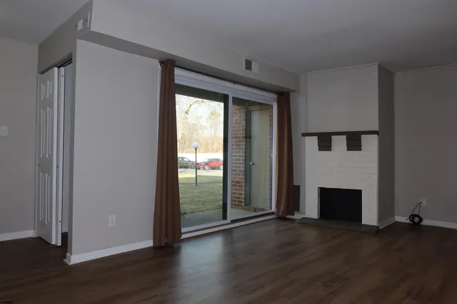a view of a livingroom with wooden floor and a fireplace
