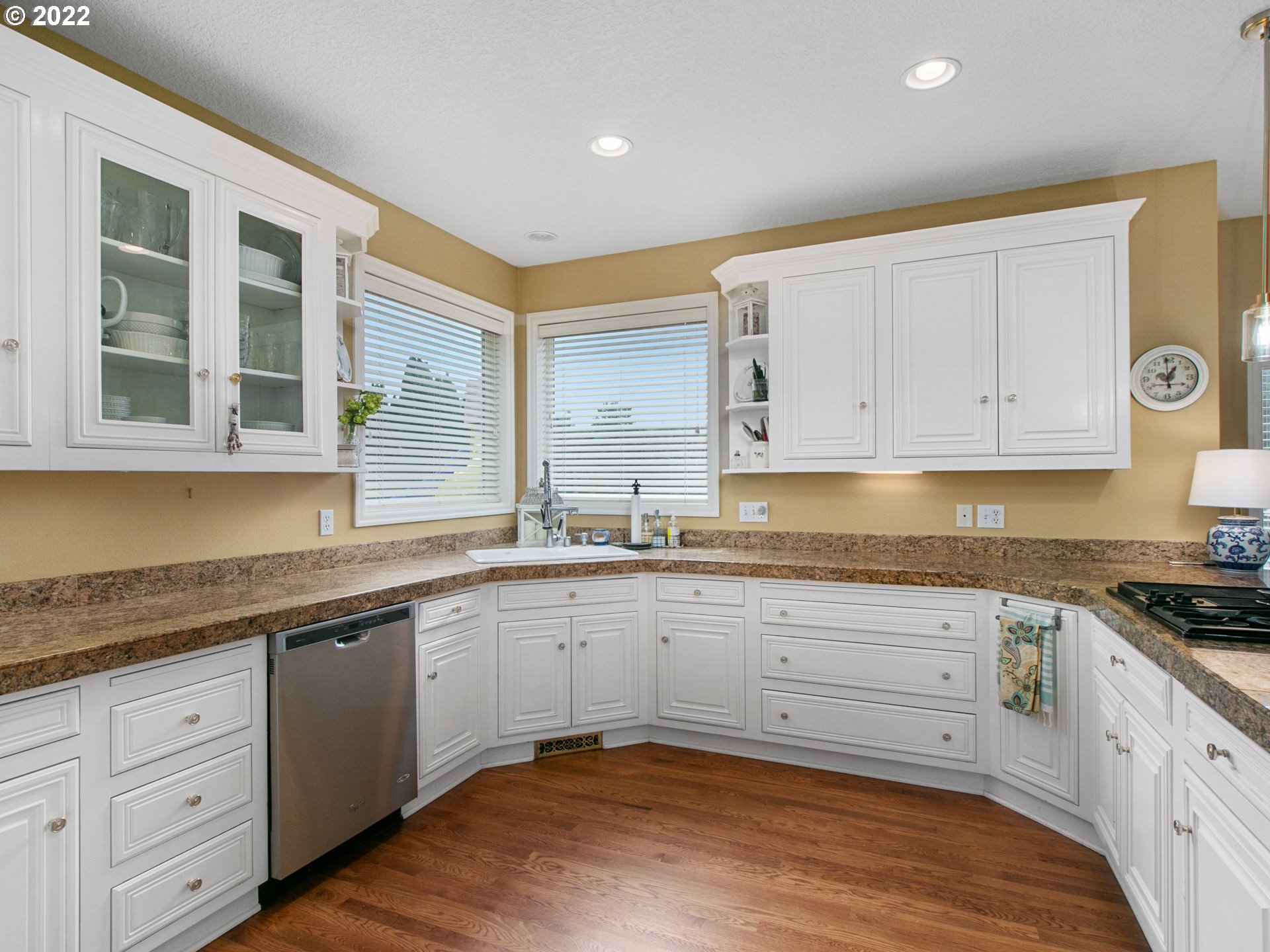 25709 Northeast 18th Court Ridgefield, WA 98642 - Photo 8 of 30 a large kitchen with granite countertop a stove a sink and dishwasher wooden cabinets with wooden floor