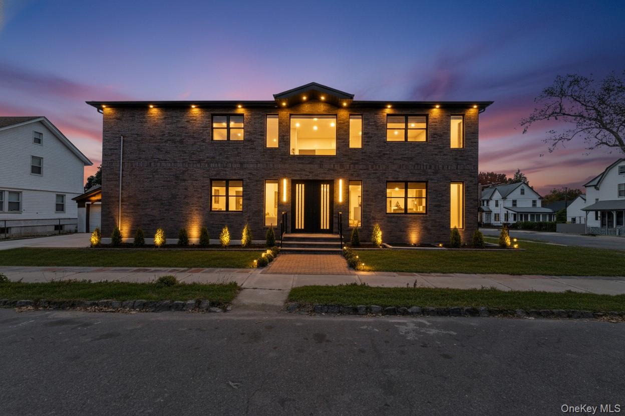 Modern home featuring a front lawn and brick siding