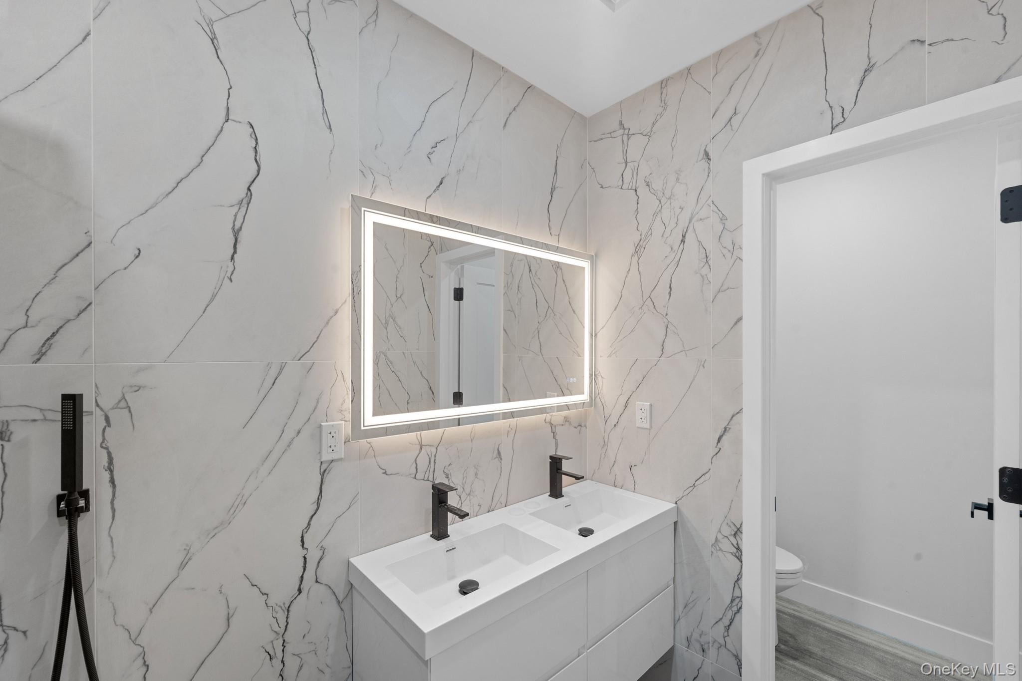 116-20 194th Street Queens, NY 11412 - Photo 12 of 27 Full bath featuring stone wall, double vanity, and tile walls