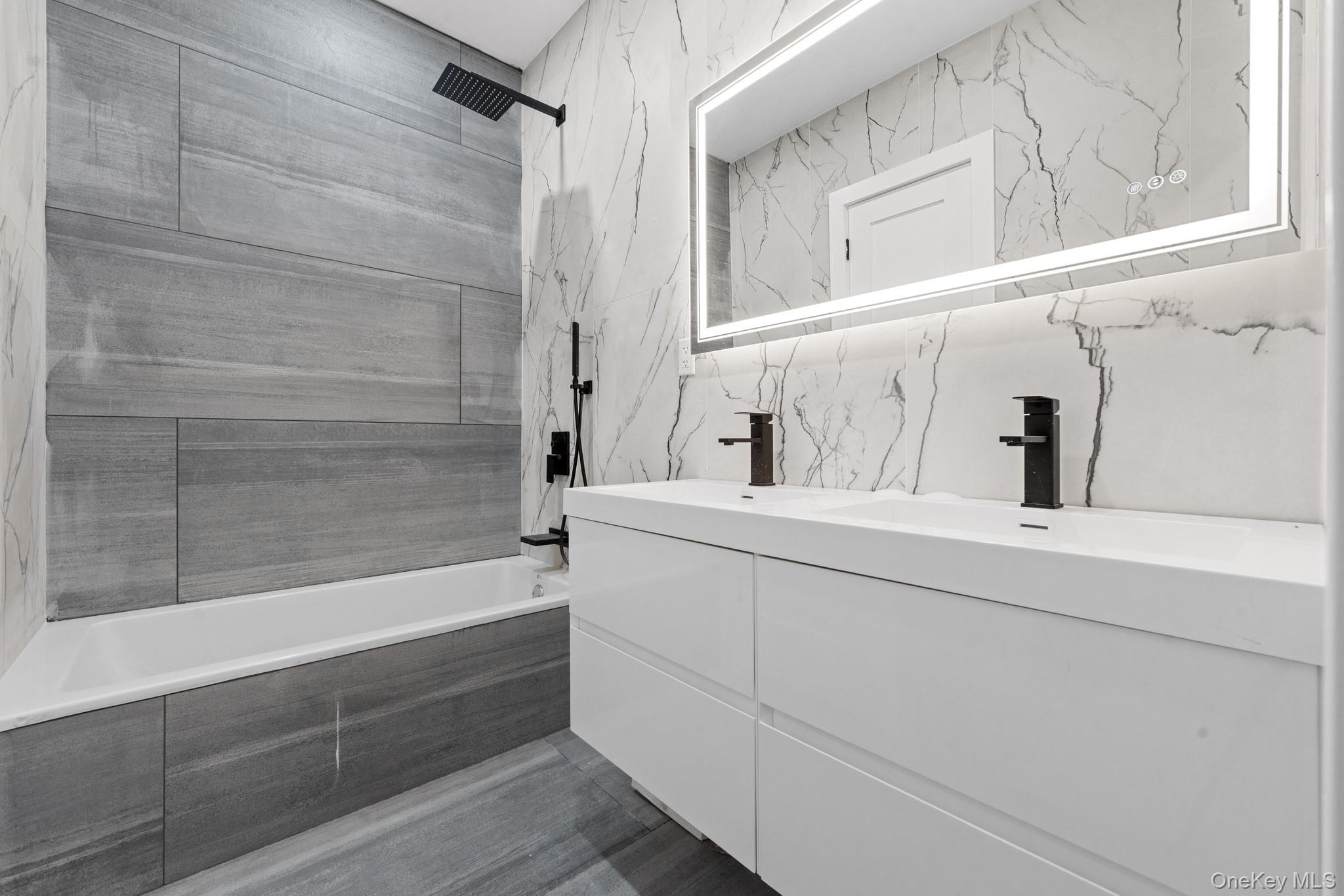 116-20 194th Street Queens, NY 11412 - Photo 13 of 27 Full bathroom featuring double vanity, tiled shower / bath, and tile walls