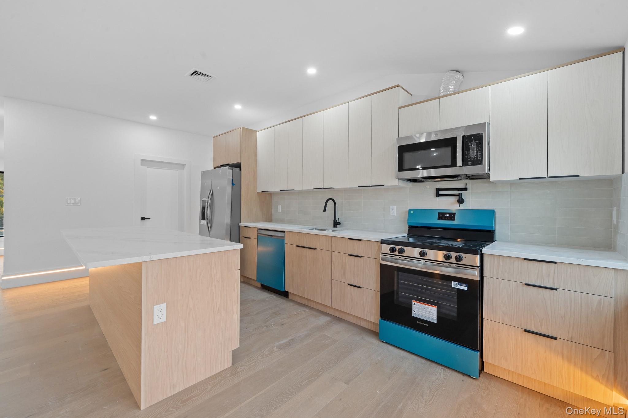 116-20 194th Street Queens, NY 11412 - Photo 15 of 27 Kitchen with appliances with stainless steel finishes, modern cabinets, backsplash, light wood finished floors, and recessed lighting