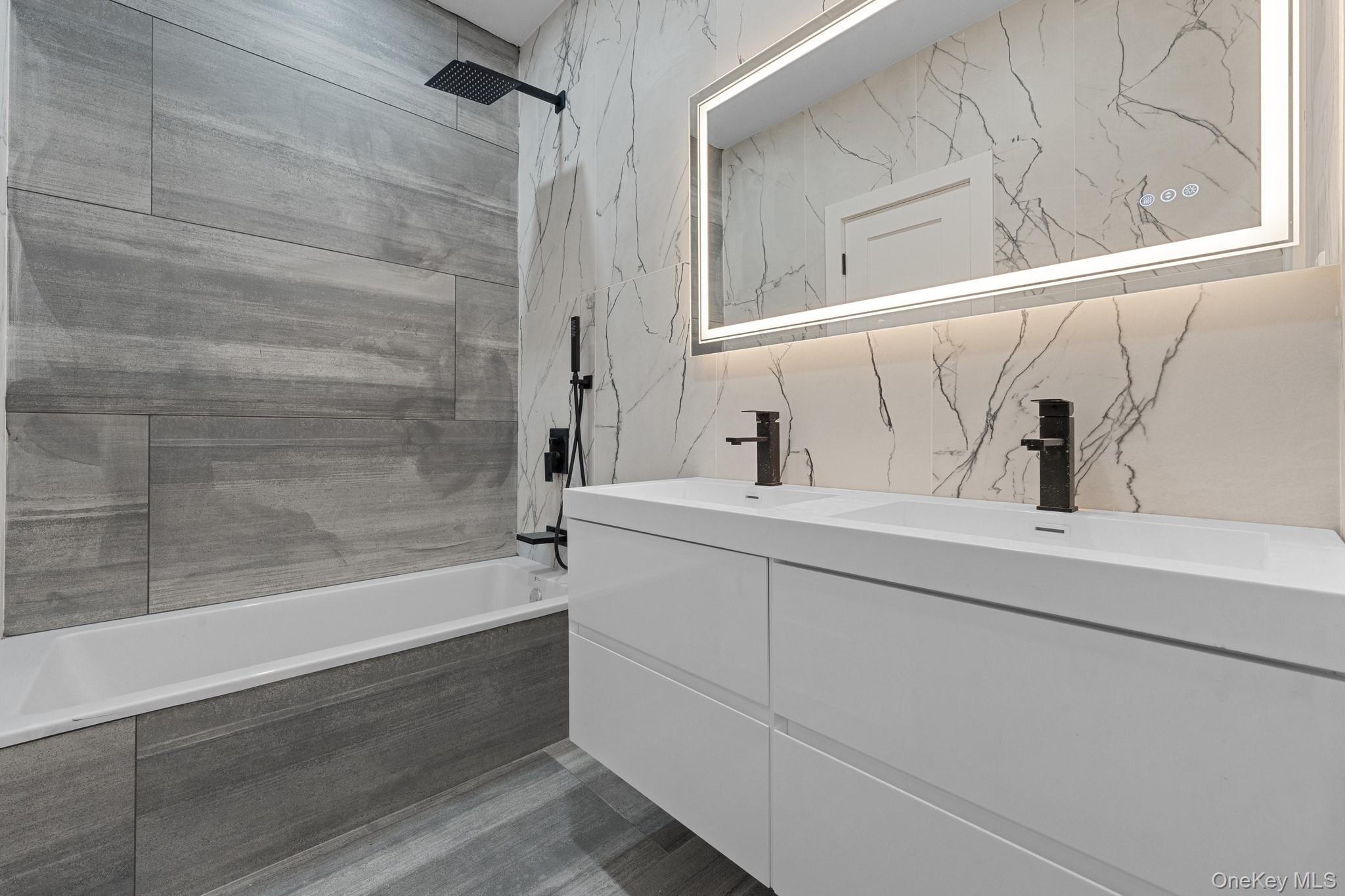 116-20 194th Street Queens, NY 11412 - Photo 21 of 27 Bathroom with double vanity, tiled shower / bath combo, and tile walls