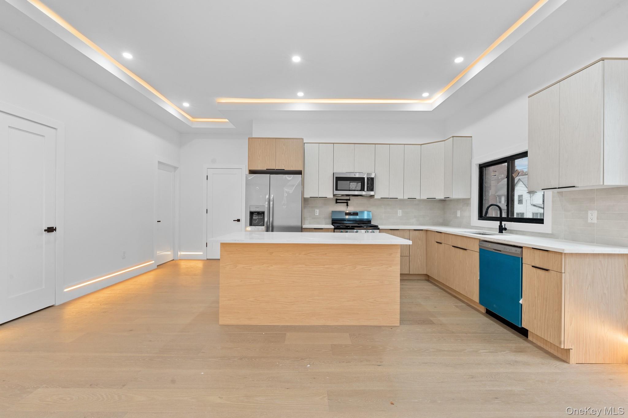 116-20 194th Street Queens, NY 11412 - Photo 4 of 27 Kitchen with tasteful backsplash, stainless steel appliances, light brown cabinets, light wood-style flooring, and recessed lighting