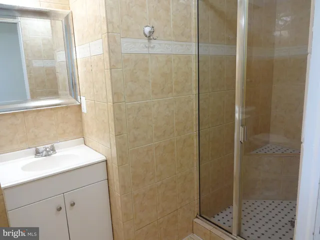 a bathroom with a shower sink and mirror