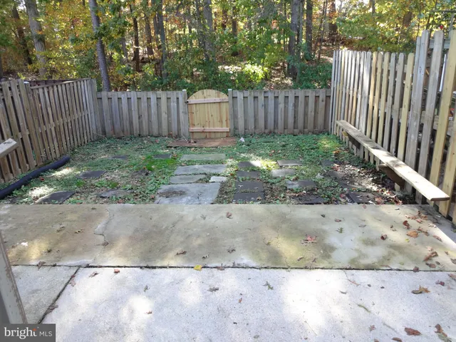 a view of a backyard with a small yard and wooden fence