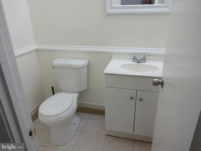 a bathroom with a sink toilet and a mirror