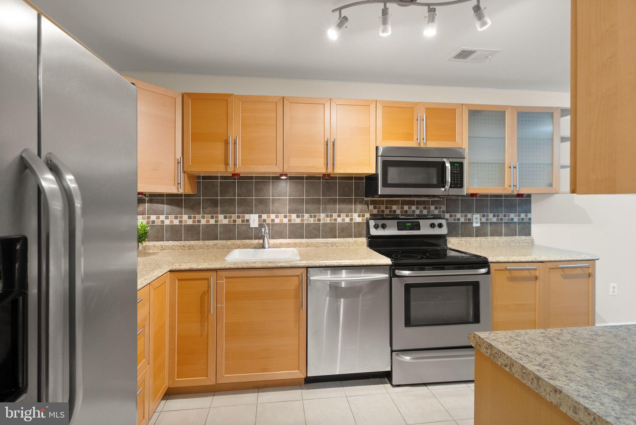 10679 Spring Oak Court Burke, VA 22015 - Photo 16 of 42 a kitchen with a stove a sink and a microwave