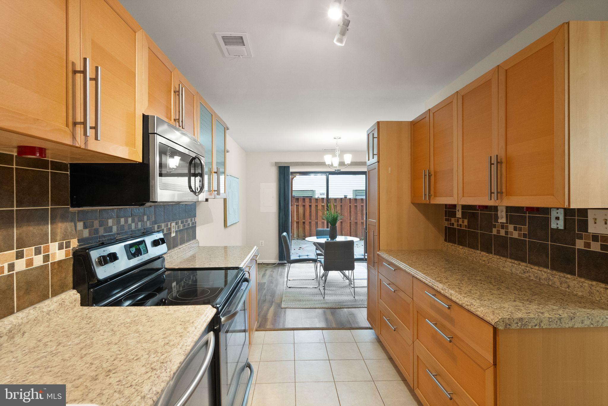 10679 Spring Oak Court Burke, VA 22015 - Photo 17 of 42 a kitchen with stainless steel appliances granite countertop a stove a sink and a microwave