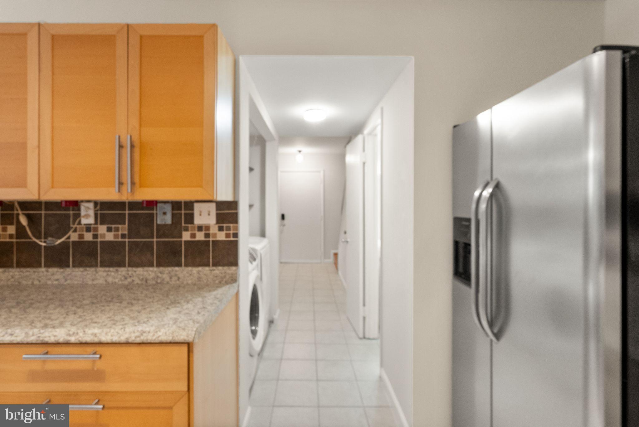 10679 Spring Oak Court Burke, VA 22015 - Photo 20 of 42 a view of a refrigerator in kitchen and an empty room