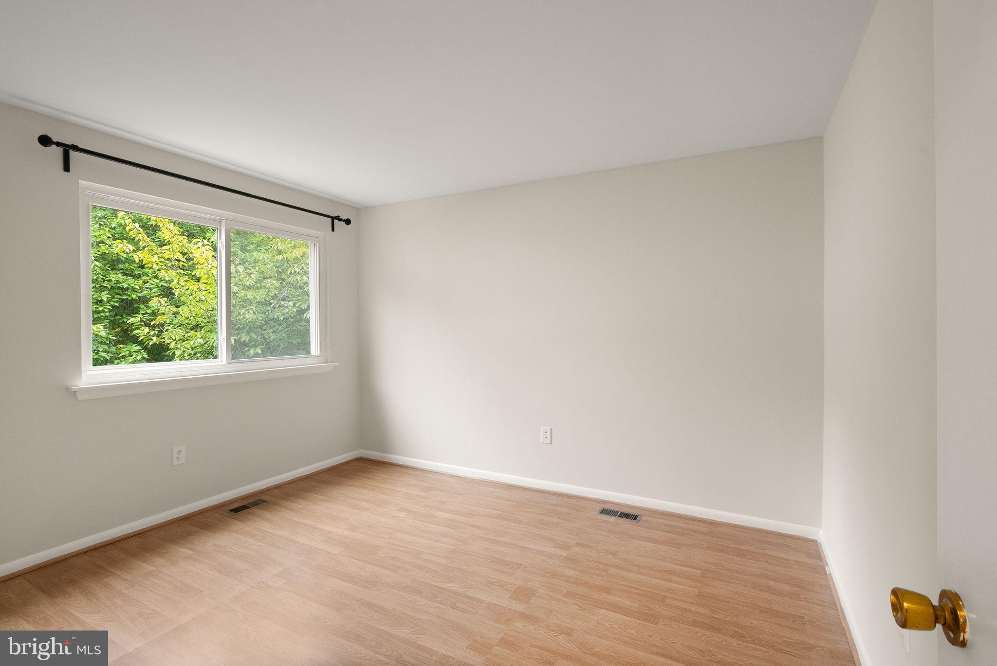 10679 Spring Oak Court Burke, VA 22015 - Photo 30 of 42 an empty room with wooden floor and windows