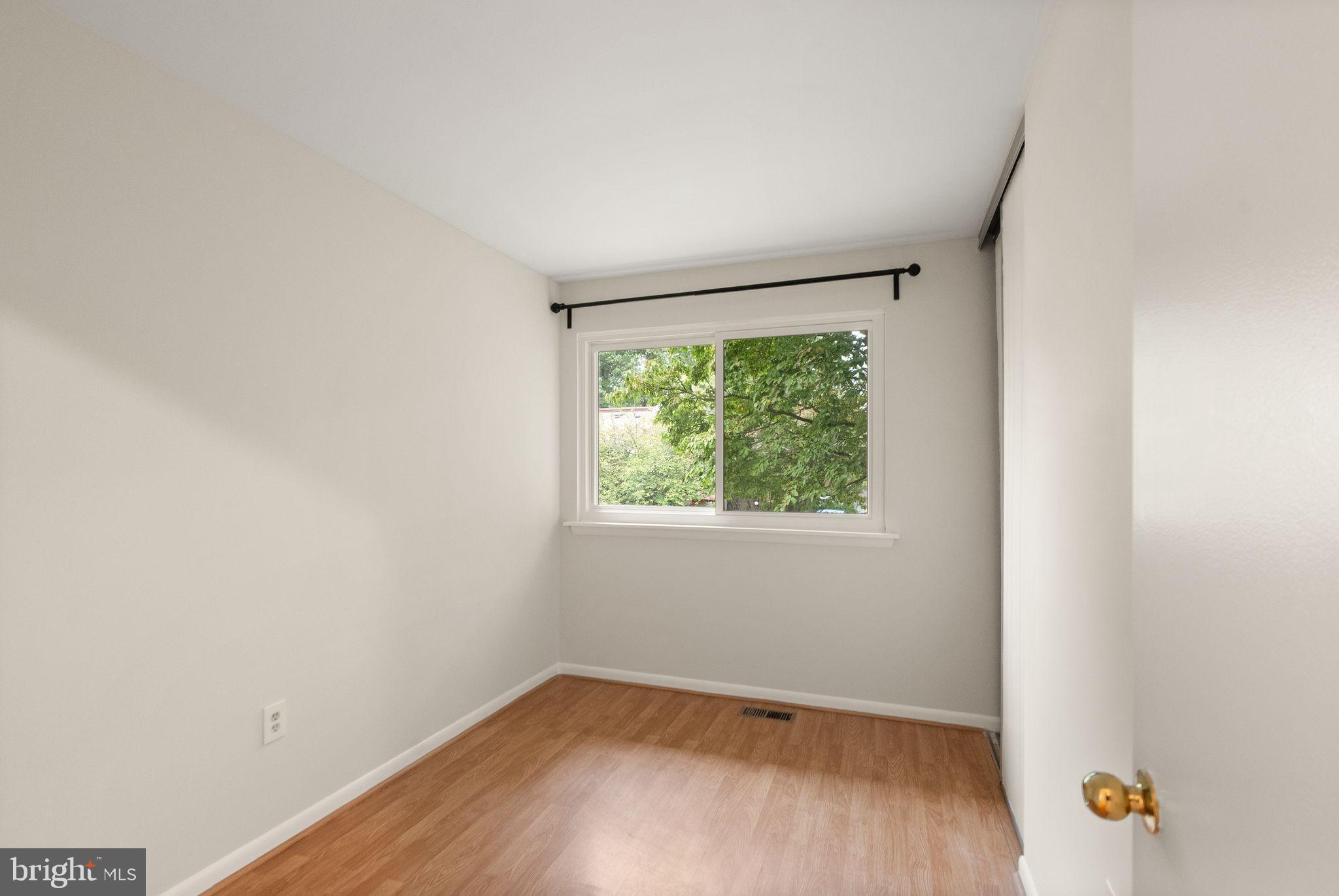 10679 Spring Oak Court Burke, VA 22015 - Photo 34 of 42 an empty room with wooden floor and windows
