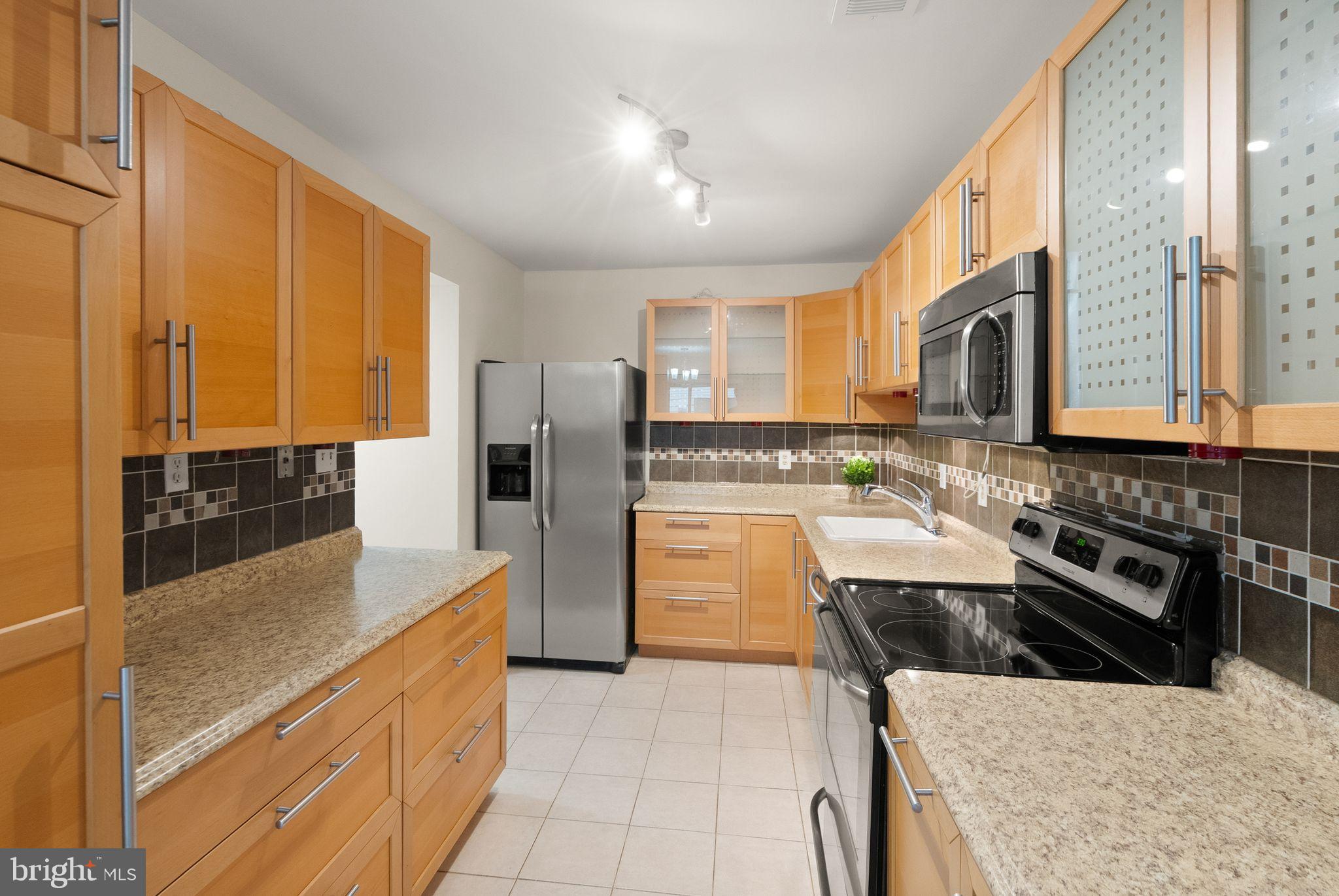 10679 Spring Oak Court Burke, VA 22015 - Photo 4 of 42 a kitchen with stainless steel appliances granite countertop a stove a sink and a refrigerator