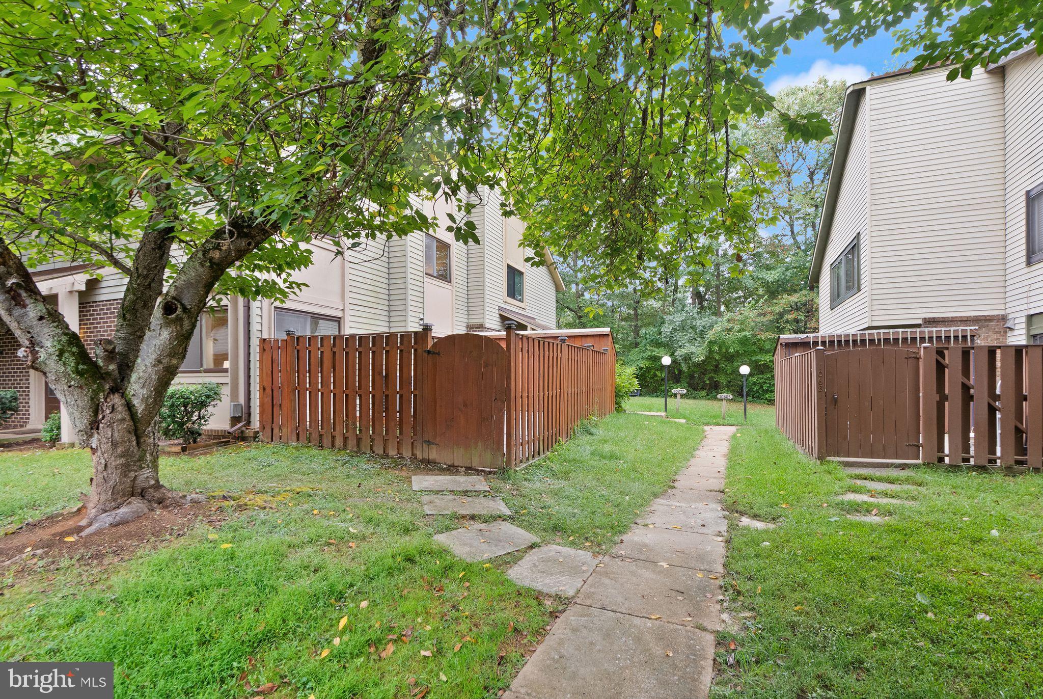 10679 Spring Oak Court Burke, VA 22015 - Photo 41 of 42 a view of a small yard with large trees and wooden fence