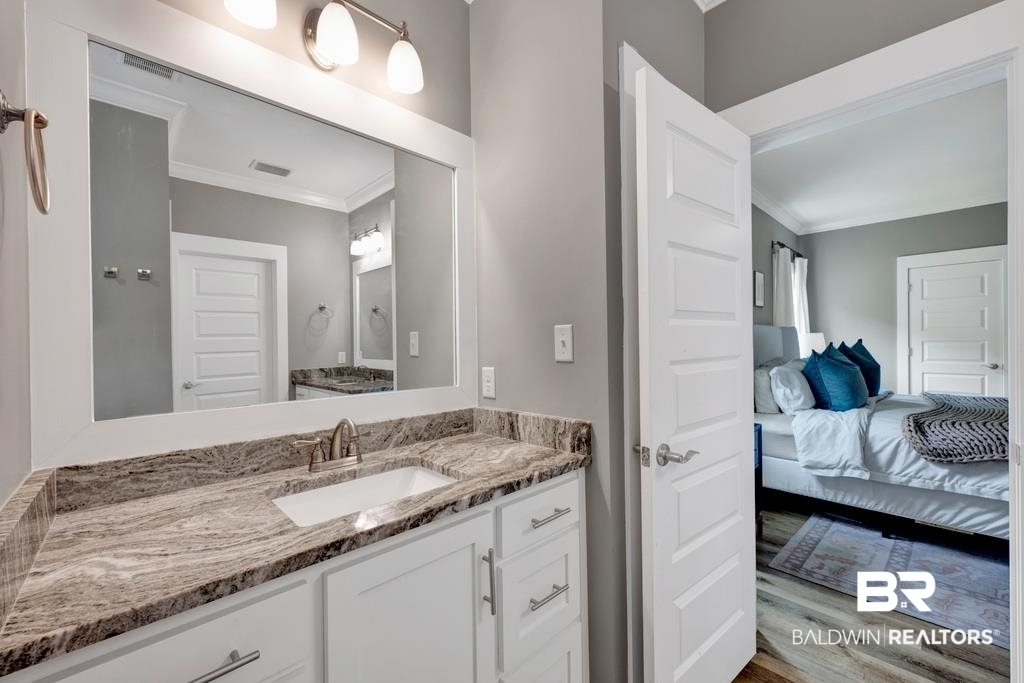 379 Pecan Ridge Boulevard Fairhope, AL 36532 - Photo 13 of 21 Bathroom vanity featuring a rectangular undermount sink, a granite-look countertop, and a framed mirror