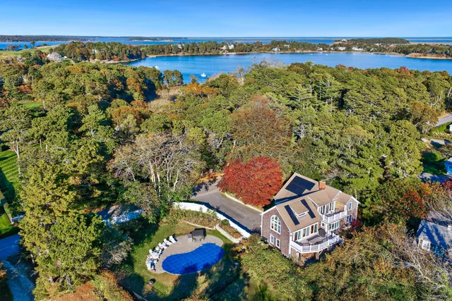 an aerial view of a house with a yard and lake view