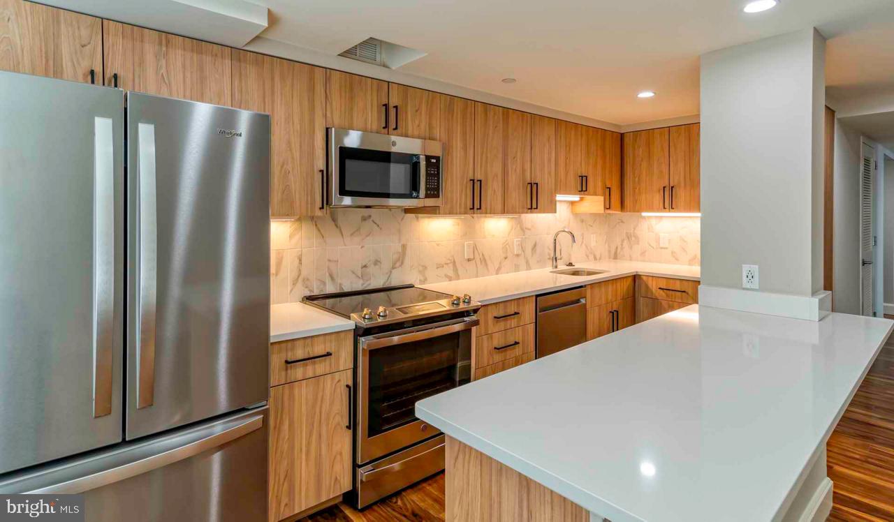 1815 John F Kennedy Boulevard, Unit 0B1917 Philadelphia, PA 19103 - Photo 16 of 16 a kitchen with stainless steel appliances granite countertop a refrigerator stove microwave and sink