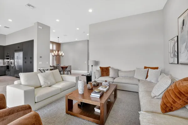a kitchen with counter top space a sink appliances and living room view