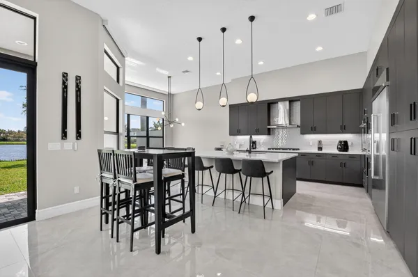 a kitchen with stainless steel appliances kitchen island a table chairs in it and wooden floors