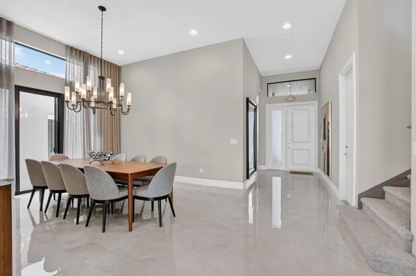 a dining room with furniture a chandelier and wooden floor
