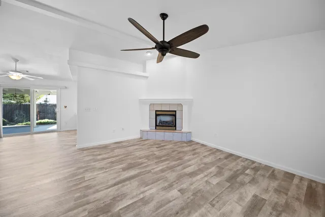 a view of empty room with wooden floor and a ceiling fan