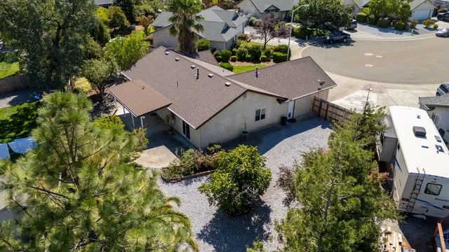 an aerial view of a house with a yard and a large tree