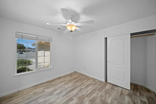 an empty room with wooden floor and window