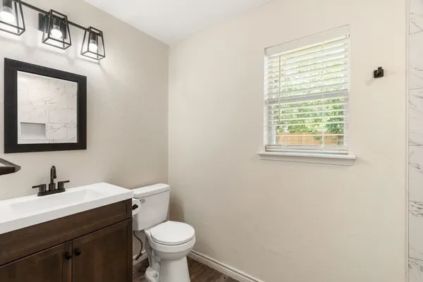 a bathroom with a toilet sink and mirror