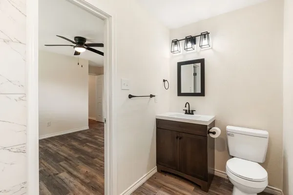 a bathroom with a toilet sink vanity and mirror