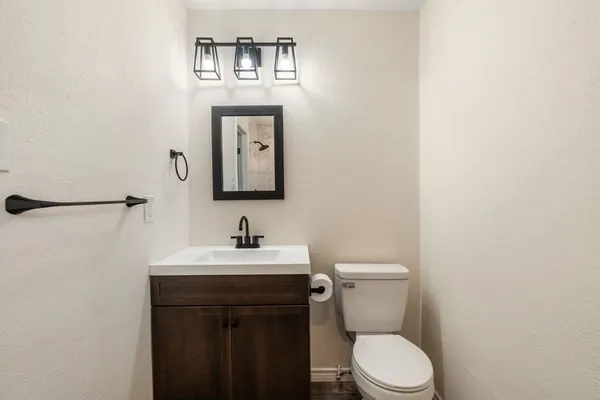 a bathroom with a toilet a sink and mirror