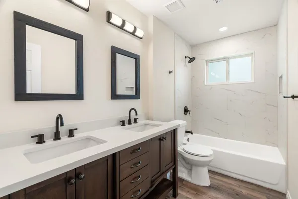 a bathroom with a toilet a sink a mirror and a bathtub