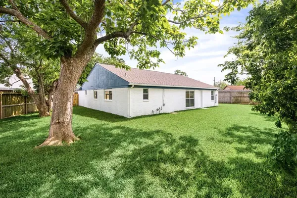 a view of a house with a yard and tree s